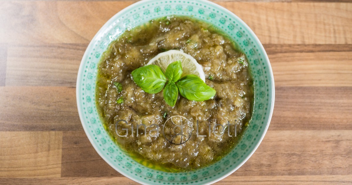 Melitzanosalata (aubergine dip) garnished with a few drops of olive oil, fresh basil leaves and a slice of lemon